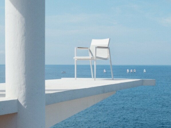 dean witte loungestoel op wit oppervlak boven de zee