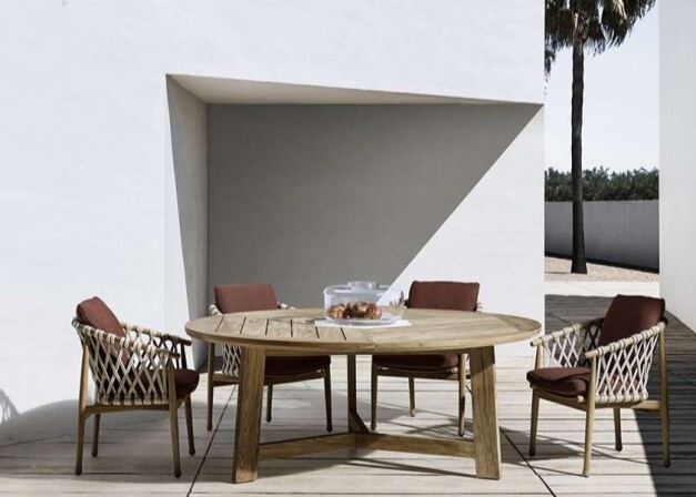 b&b italia ginestra table de jardin chaises tressées bordeaux le long d'un mur blanc vue latérale