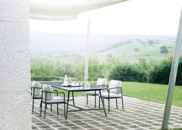 b&b italia borea tuintafel zwart met witte kussens in berglandschap