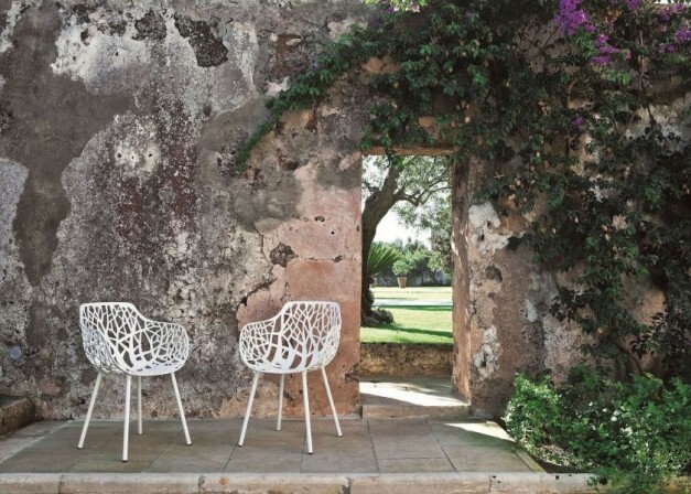 fast forest witte tuinstoelen langs eens stenen muur met doorgang