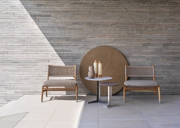 loungestoelen langs een witte stenen muur met schaduw voorzijde