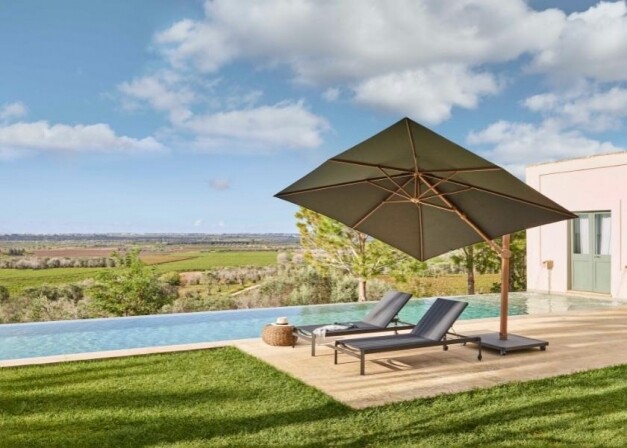 jardinico antego groene parasol hout over grijze ligstoelen heen langs het zwembad