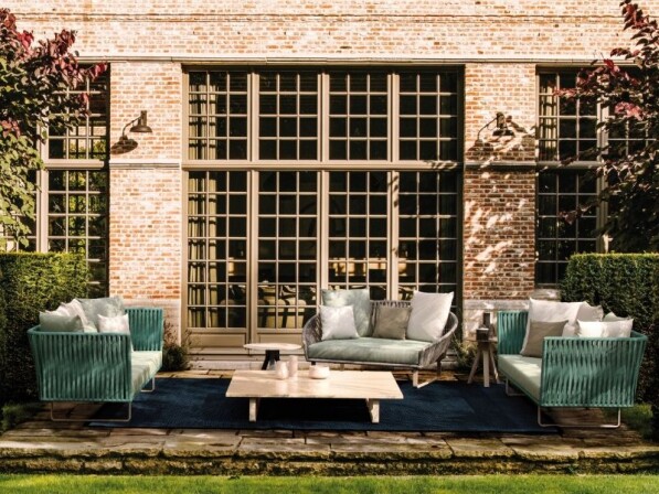 groen witte loungeset met licht houten tafel voorzijde voor een groot terrasraam