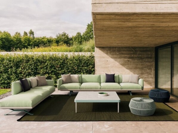 groene loungeset op een groen tapijt voorzijde deels onder een houten afdak
