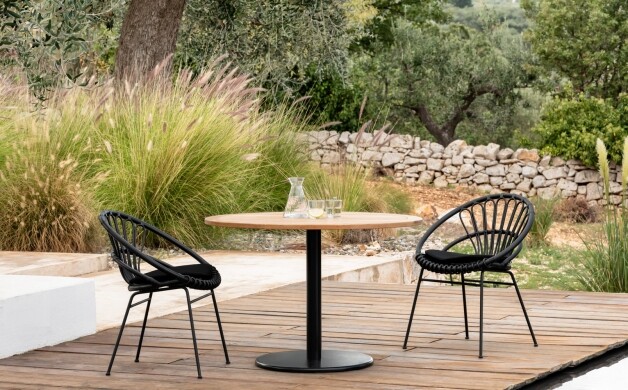 vincent sheppard roxanne dining chair ronda bistro table donker op een houten paltform en groene tuin
